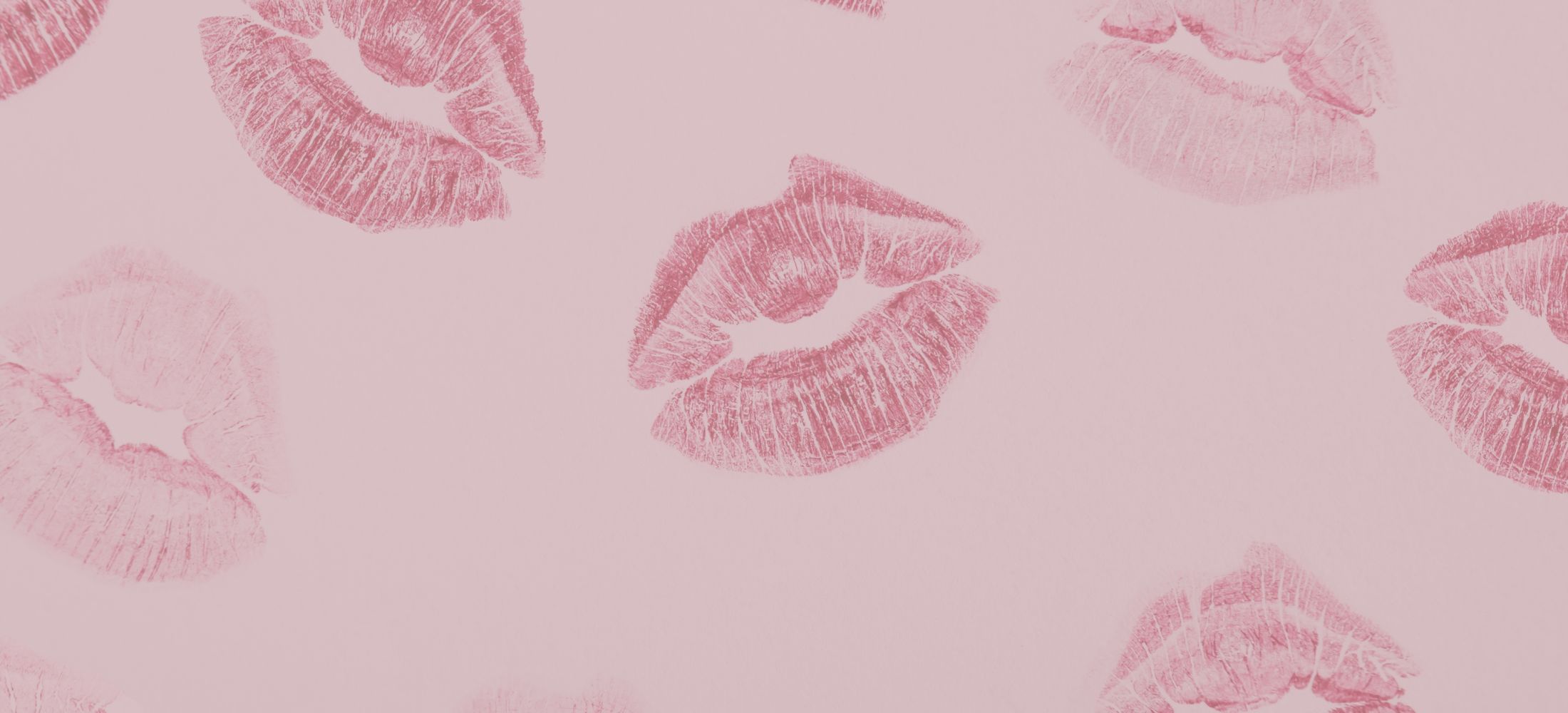 Two women in swimsuits smiling by the ocean.