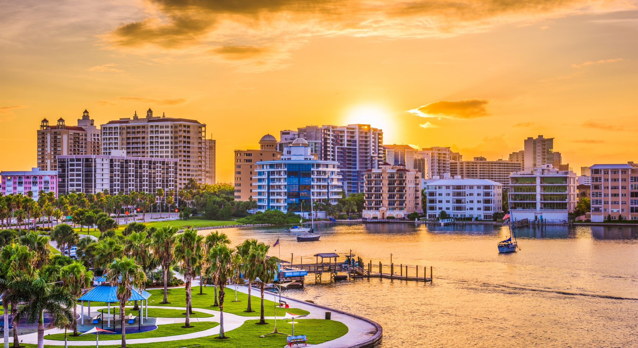 Sunset over city skyline and waterfront park.